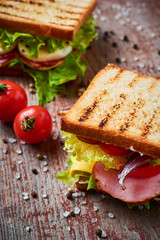 Sanswich with lettuce and ham on a wooden background