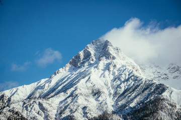 Obraz premium Epic snowy mountain peak with clouds in winter, landscape, alps, austria