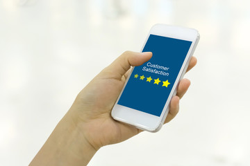Customer satisfaction review business concept. Woman hand using smartphone with satisfaction rating online mobile application