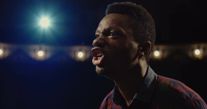 Medium close-up shot of an actor performing a monologue in a theater while holding his script
