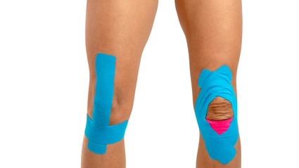 Female knee with physio tape on white background