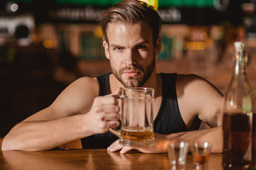 He is a big fan of beer. Addicting to alcoholic drink. Alcohol addict with beer mug. Man drinker in pub. Handsome man drink beer at bar counter. Beer restaurant. Alcohol addiction and bad habit