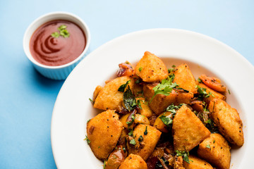 Masala fried Idlies or Idli fry - south indian Snack made using with leftover idly served with tomato ketchup. selective focus