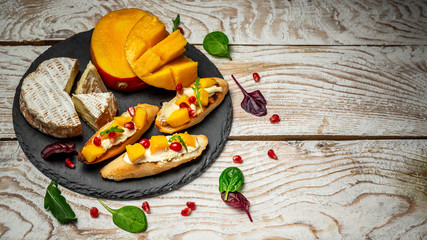 Top view of Bruschetta with sweet mango and cheese. on a light wooden background. Healthy food