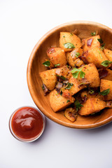Fototapeta premium Masala fried Idlies or Idli fry - south indian Snack made using with leftover idly served with tomato ketchup. selective focus