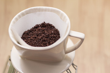 Drip coffee with paper filter tool on wood background