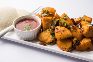 Masala fried Idlies or Idli fry - south indian Snack made using with leftover idly served with tomato ketchup. selective focus