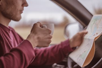 young male tourist drinking fresh coffe in car in wide forest in aurumn season b