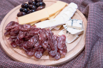 Meats, sausages, olives, laid out on a wooden board close-up - Image