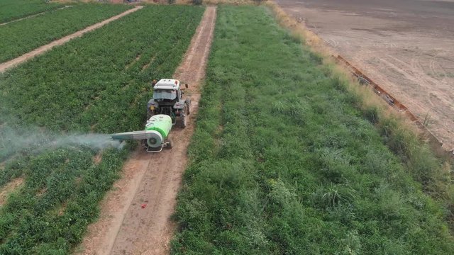 Aearial view of tractor spraying cultivated field. Farming,agriculture,machinery