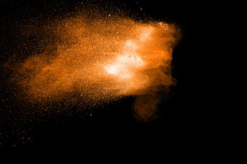 Fototapeta na wymiar Orange color powder explosion on black background.