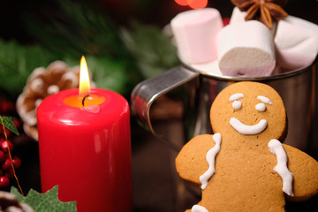 ginger biscuit and marshmallow on brown background with Christmas tree ,  candles and christmas lights. 