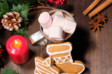 ginger biscuit and marshmallow on brown background with Christmas tree ,  candles and christmas lights. 