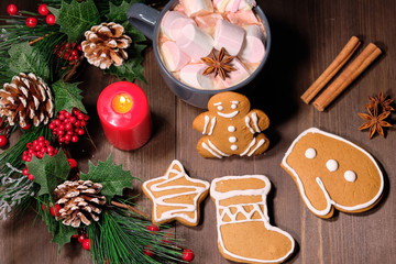 ginger biscuit and marshmallow on brown background with Christmas tree ,  candles and christmas lights. 