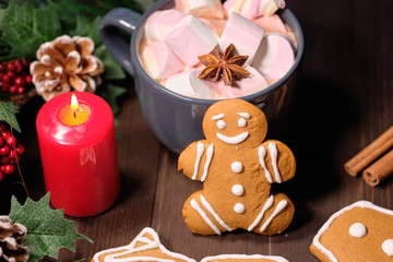 ginger biscuit and marshmallow on brown background with Christmas tree ,  candles and christmas lights. 