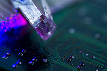 Internet switch , glowing optical fibres on computer circuit board, space for text.