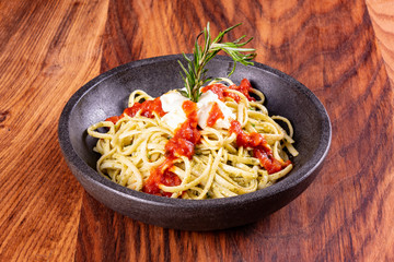 Closeup of spaghetti with fresh basil pesto.