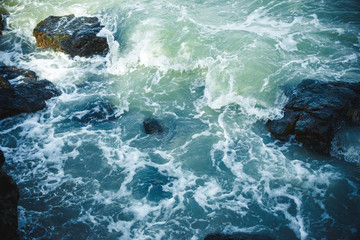 Top view of small waves hitting and splashes against the sea shore at Phuket beach in Thailand. Waves hitting rock.