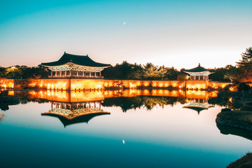 The pavilions of Anapji Pond reflected in the water in Gyeongju.The Gyeongju Historic Areas of South Korea were designated as a World Heritage Site by UNESCO in 2000, ref 976. Teal and orange view.