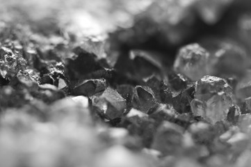 Black and white photograph of the structure of the surface of crystals. Close-up. Blurred background.