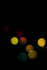 bokeh blue, green, yellow, red tones on black background on New Year's Eve