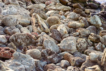 Multi-colored stones boulders on the seashore