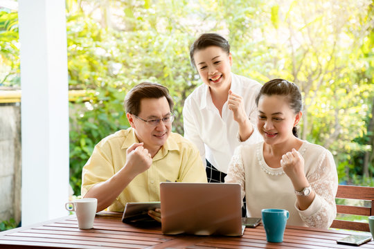 Group Asian elderly men and women are living the tablet and laptop happily with a smile of friendship. By searching for health care information tourism And investment after retirement. Elderly concept