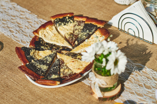 Delicious baked wedding cake and pastry set up on the ructic wooden table