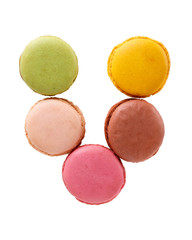 Letter V from multi-colored macaroon cookies. Flat lay, top view, isolated on white.