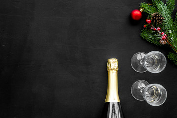New year and Christmas party with spruce, champagne bottle and glasses on black background top view space for text
