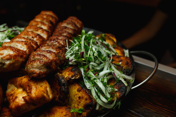 Shish kebab, kebab on a dark background. Different fried meat in plate