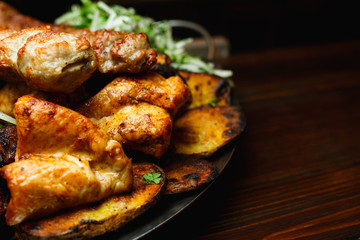 Shish kebab, kebab on a dark background. Different fried meat in plate