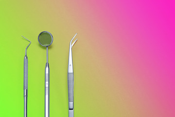 Dentist tools: mirror, dental probe and tweezers on pink green gradient background.