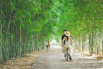 Fototapeta premium Happiness couple ride a bicycle in the bamboo park