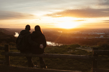 Couple profitant du coucher du soleil avec ville en contrebas