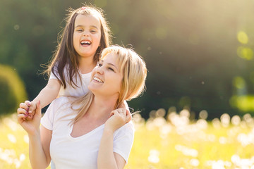Beautiful Mother And her little daughter outdoors. Nature. Beauty Mum and her Child playing in Park...