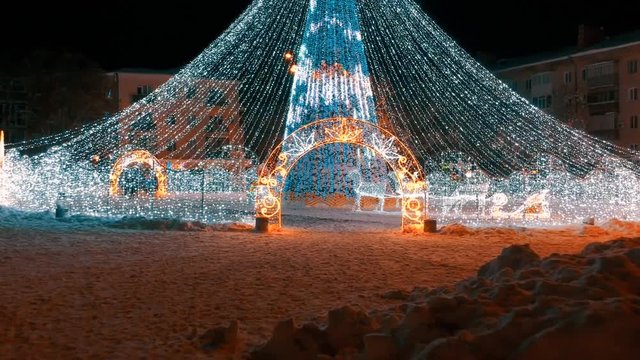 Christmas tree at the snowy night with street lights in European city
