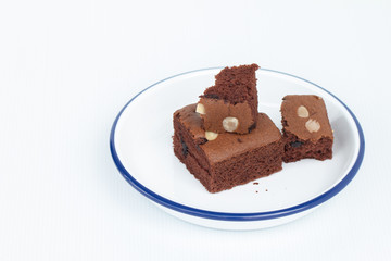 Homemade chocolate brownies topping with almond slices in white bowl