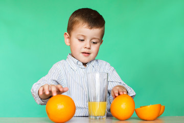 Little boy with oranges and juice.