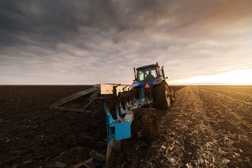 Fototapeta premium Tractor Plowing in dusk