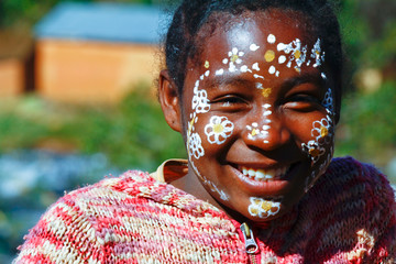 Girl with traditionally painted face, Madagascar - obrazy, fototapety, plakaty