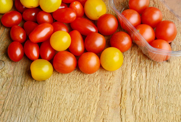 Tomato Varieties ,Type and color mixed together in box on wooden floor. A lot kind and different color of tomatoes.