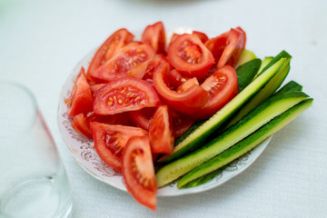 Sliced cucumbers and tomatoes on a plate.