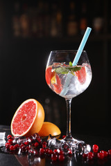 Alcoholic cocktail on the bar counter in a tall wine glass with pieces of grapefruit. Alcoholic drink for the holiday. The concept of celebration and fun.