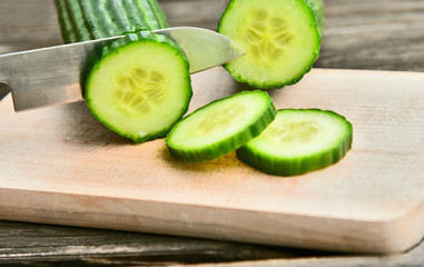 Cucumber seeds are edible and very nutritious..Fresh Cucumber slice on wooden board with wooden background.