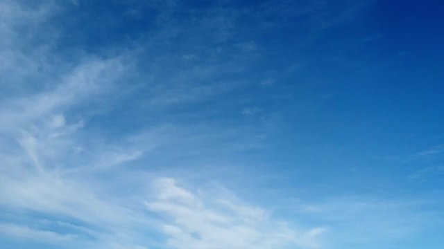 Flying in a blue sky with fluffy withe cirrus  clouds with blue summer sky background  in Time lapse