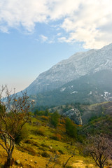 Green foothills and snowy mountain. blue sky and cloud clusters.