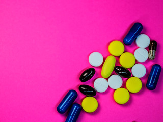 Various medical pills on pink background