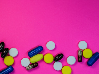 Various medical pills on pink background