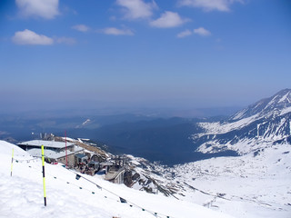 Skiing slope during winter with mountains in the background.